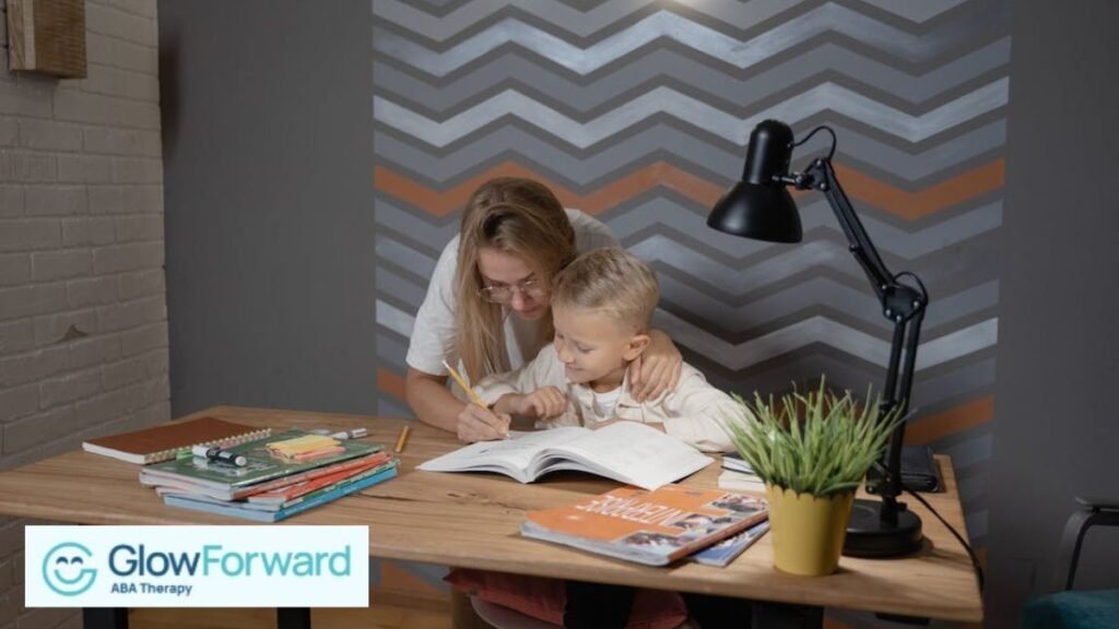 A woman guides a young boy as they look at a book together in a home office with geometric patterns.