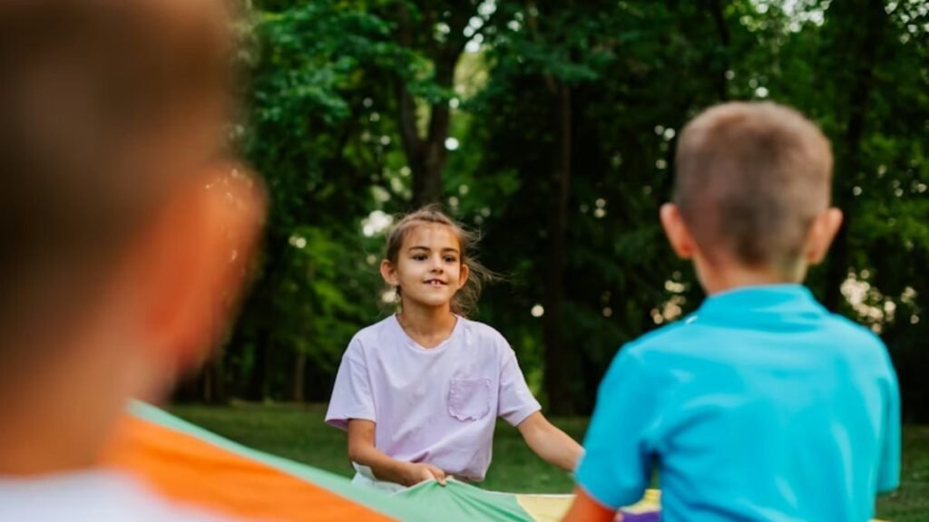 Social skills for autistic children, a group of children unfold tent fabric during a cooperation game.