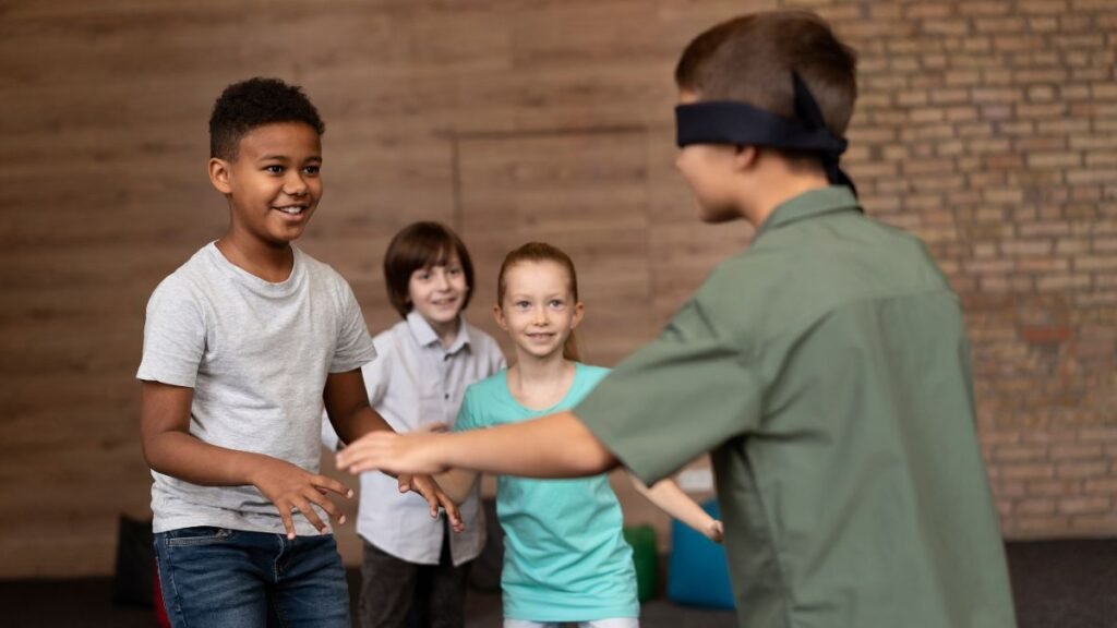 Social skills for autistic children, a blindfolded boy is guided by peers during a communication and trust activity.